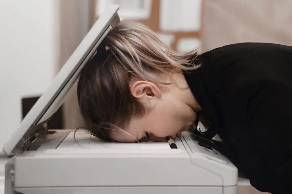 Businesswoman sleeping on printer at office. Overworked concept.